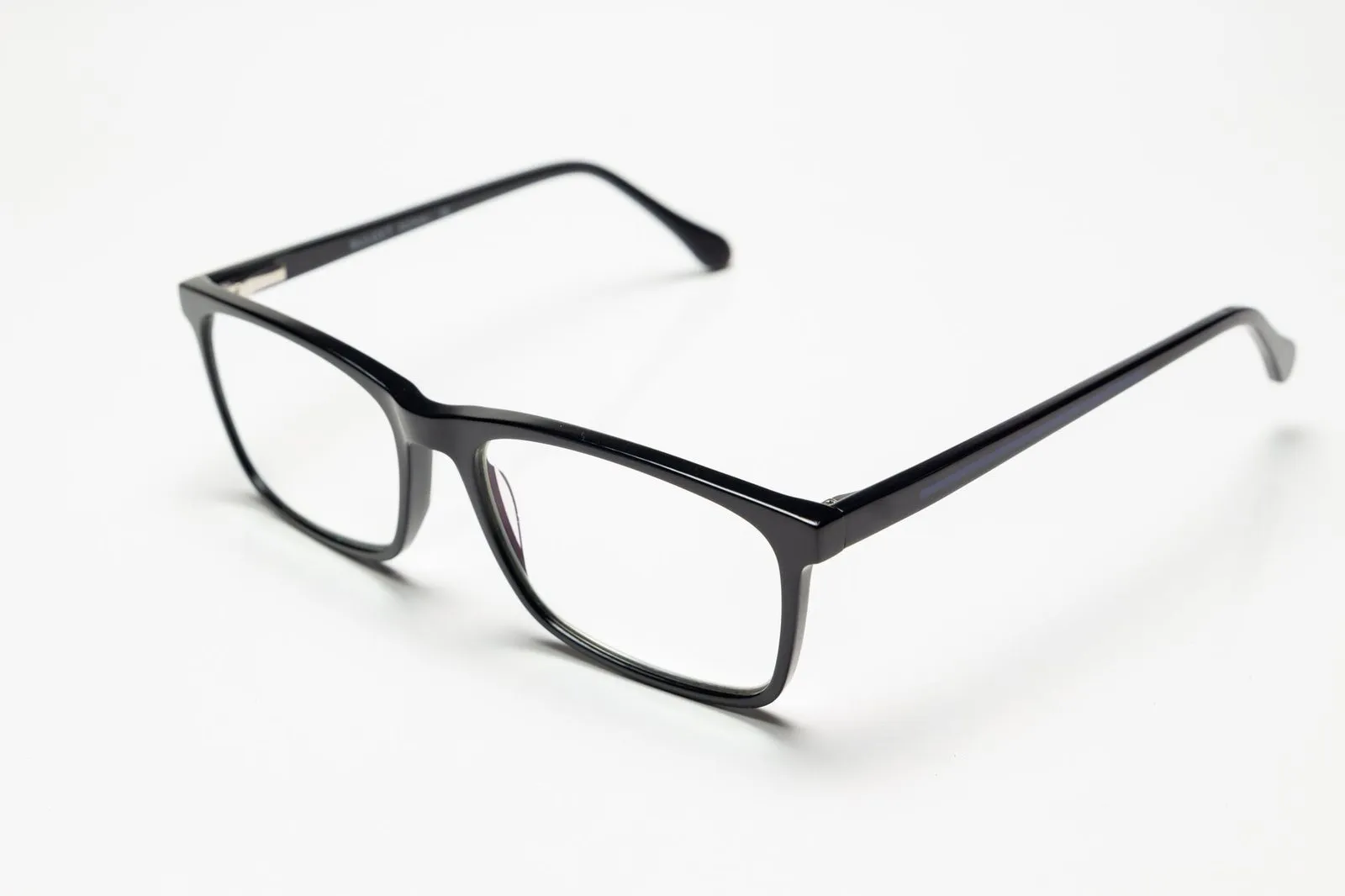 Black rectangular acetate glasses on a white surface