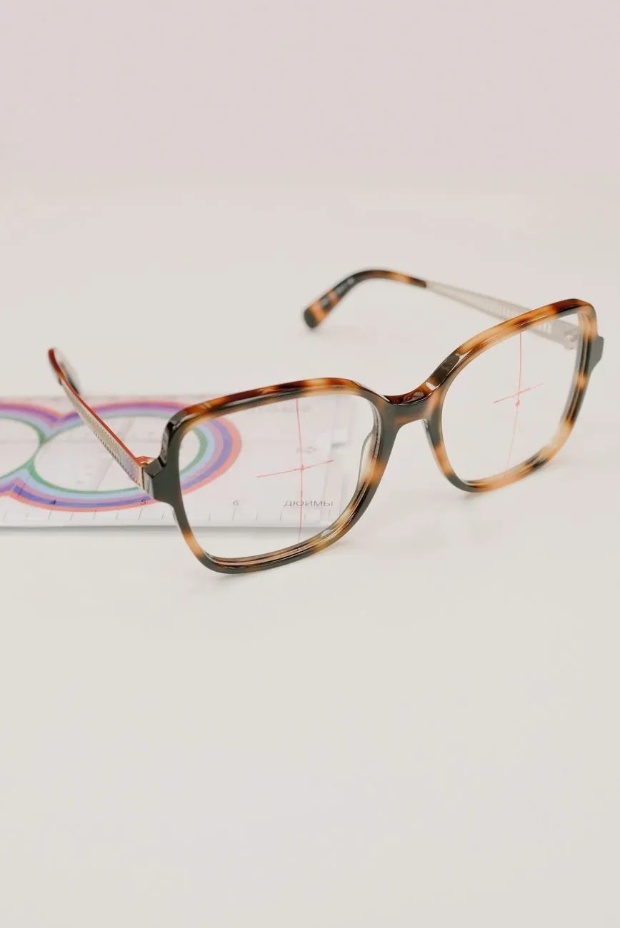 Square tortoiseshell glasses resting on a lens-measuring card